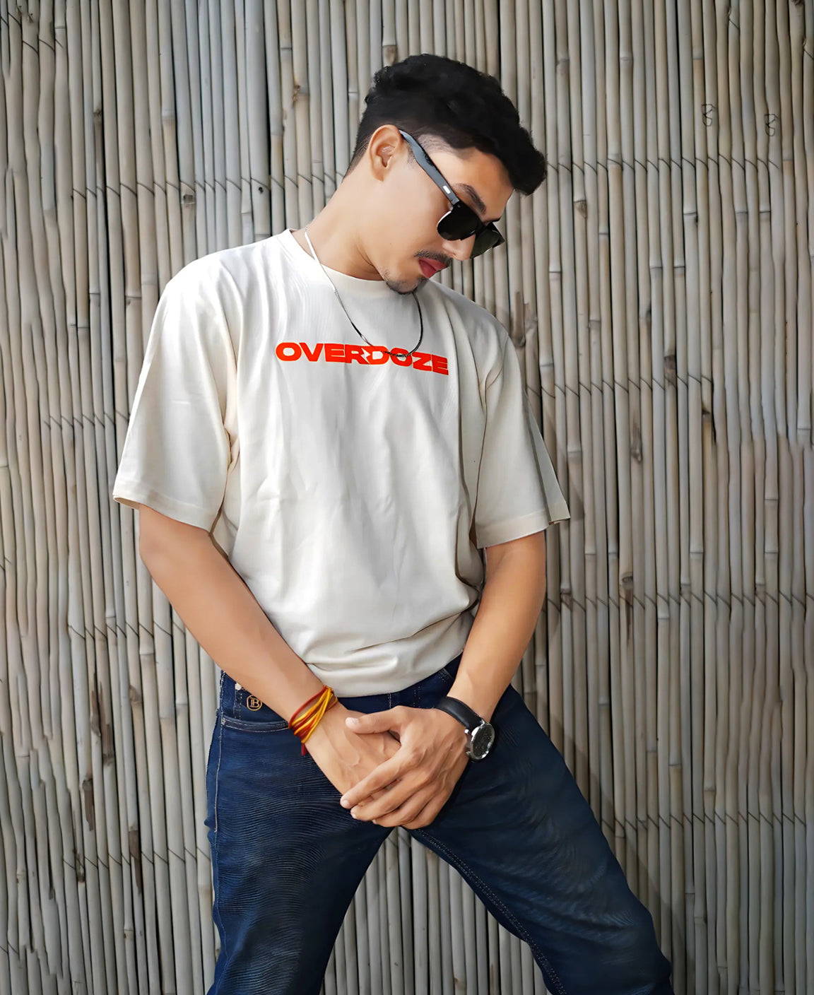 Person wearing a white t-shirt with 'OVERDOZE' printed on it, standing against a textured wall.